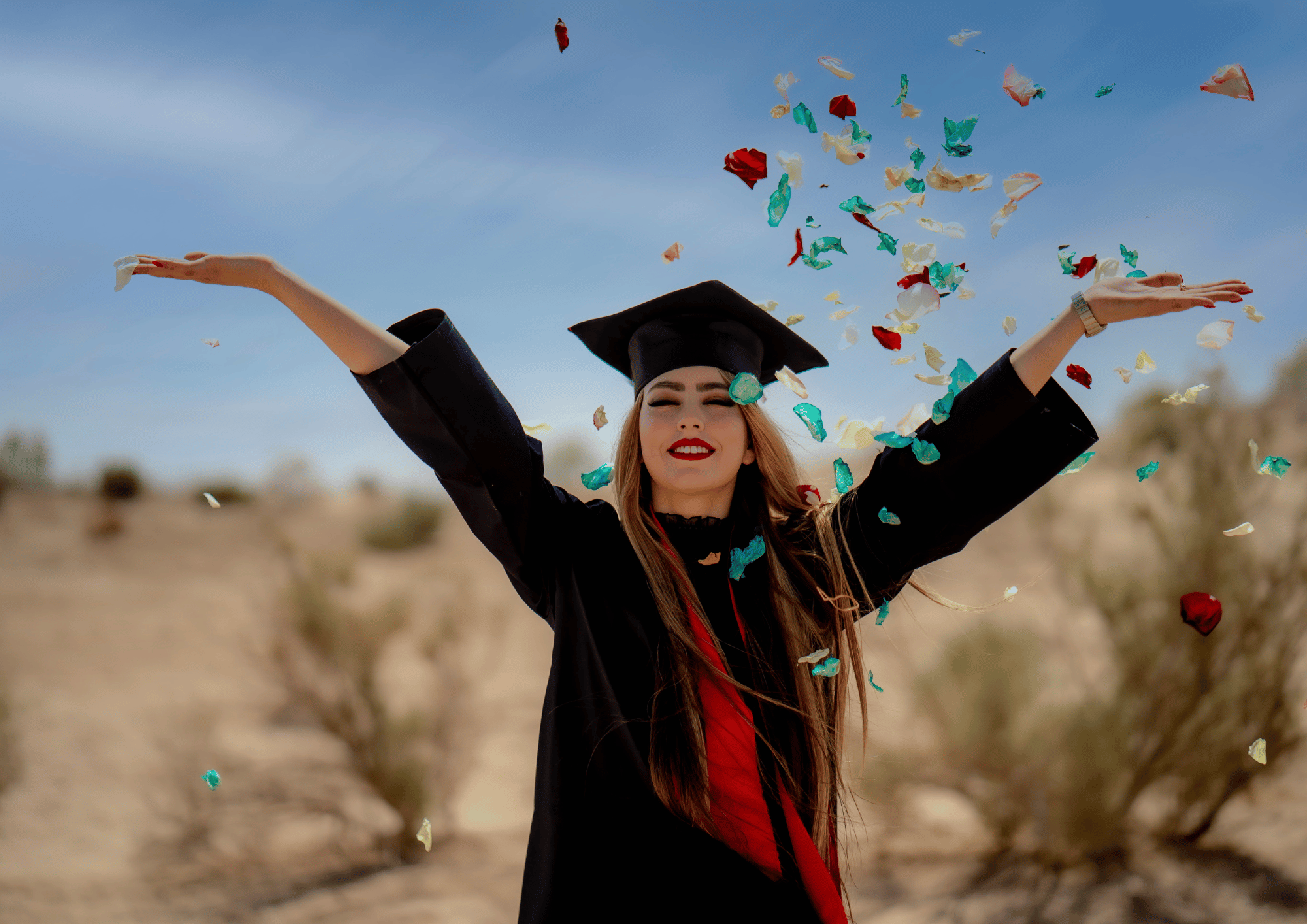 Last-Minute Graduation Gifts: A happy graduate throwing confetti in the air while wearing a black cap and gown.