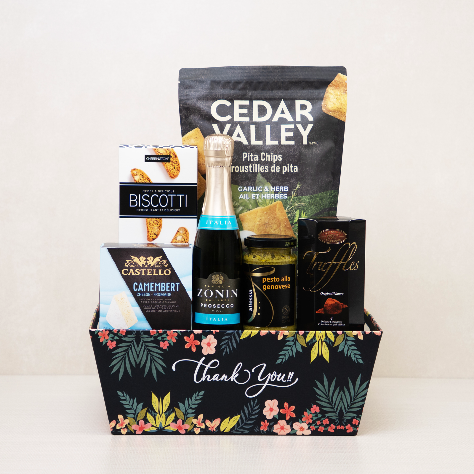 Thank You Gift Basket with mini sparkling wine, truffles, biscotti, and more snacks in a decorative floral keepsake basket.