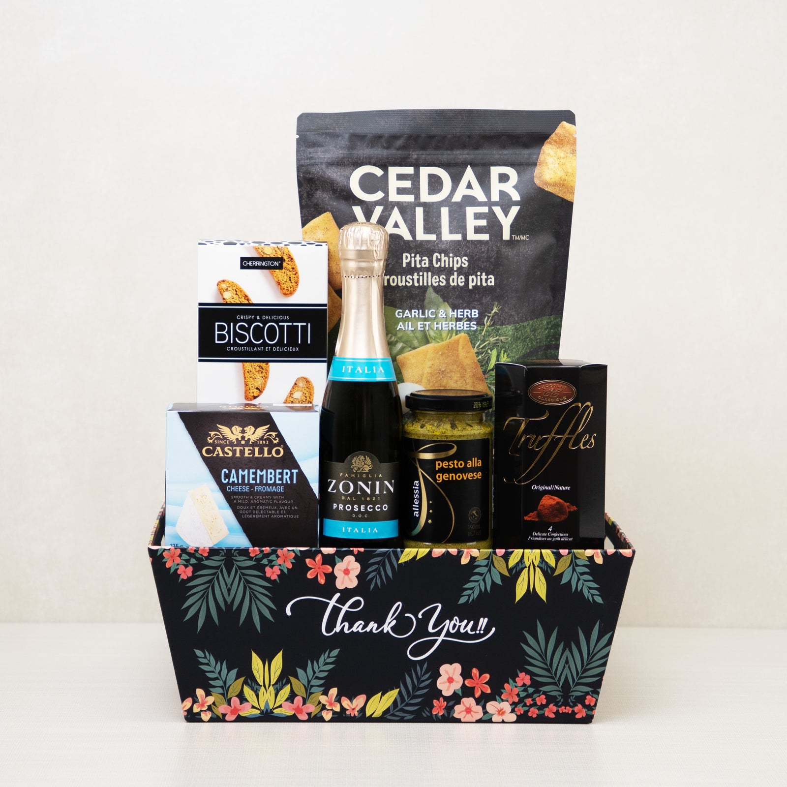 Thank You Gift Basket with mini sparkling wine, truffles, biscotti, and more snacks in a decorative floral keepsake basket.