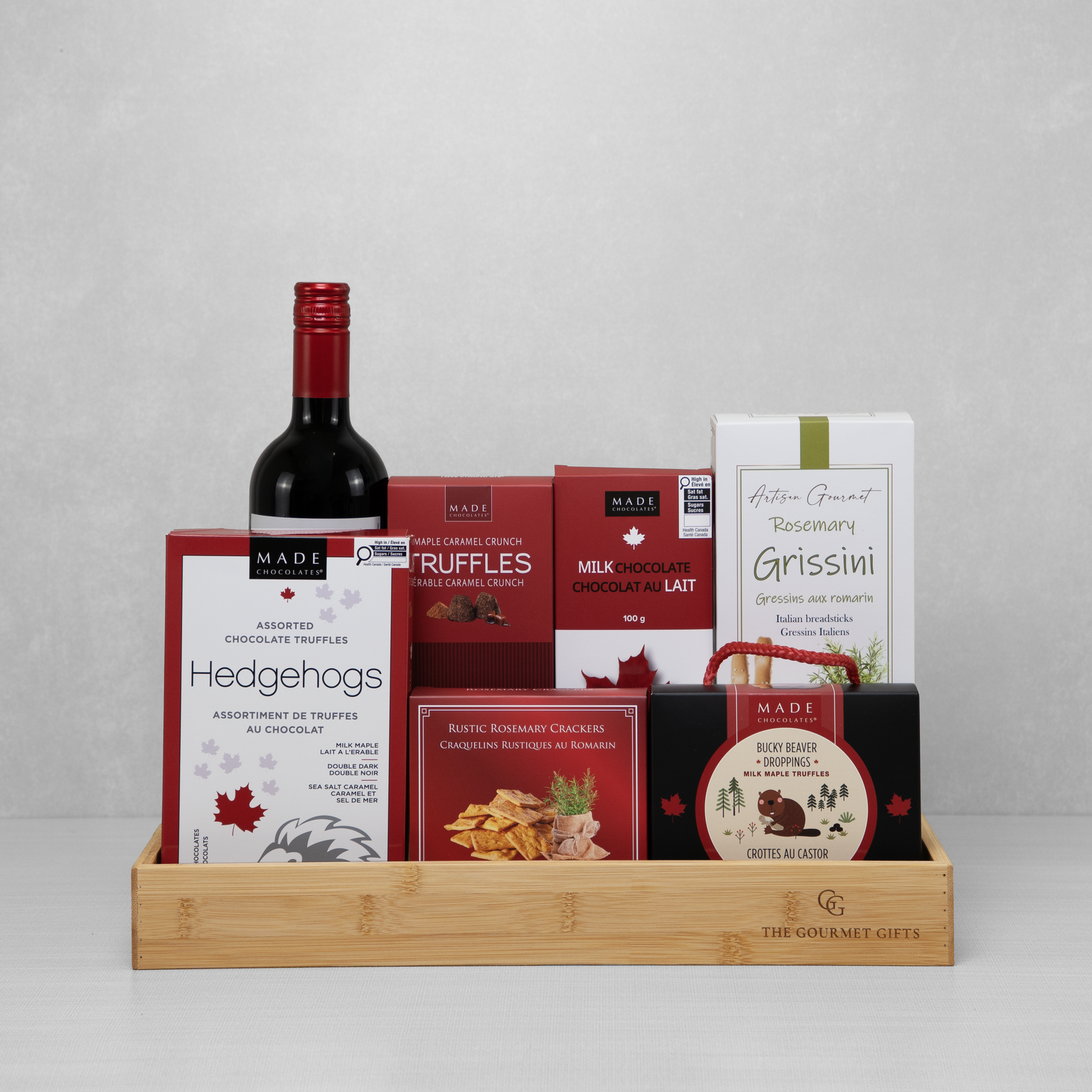Gourmet Celebration Collection with red wine, chocolates, crackers, truffles, and breadsticks.