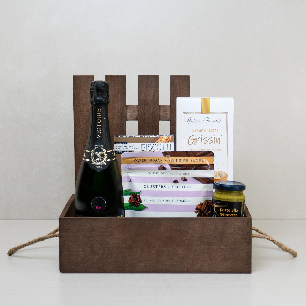 Champagne Delight Wooden Crate with champagne, almond biscotti, basil pesto, and dark chocolate clusters in a wooden crate.