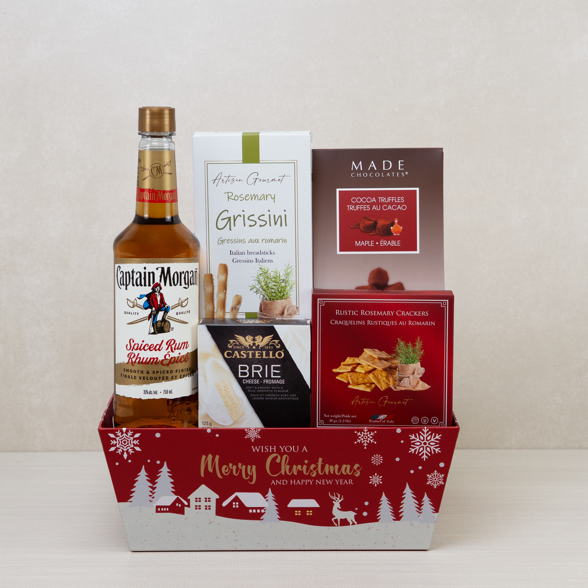 Christmas Spiced Rum Gift Basket with rum, maple truffles, crackers, and breadsticks in a red holiday basket