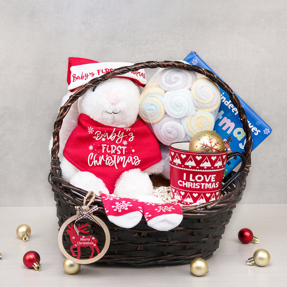 Baby's First Christmas Basket with a plush bunny in a matching hat and bib, socks, I Love Christmas mug and rolled washcloths