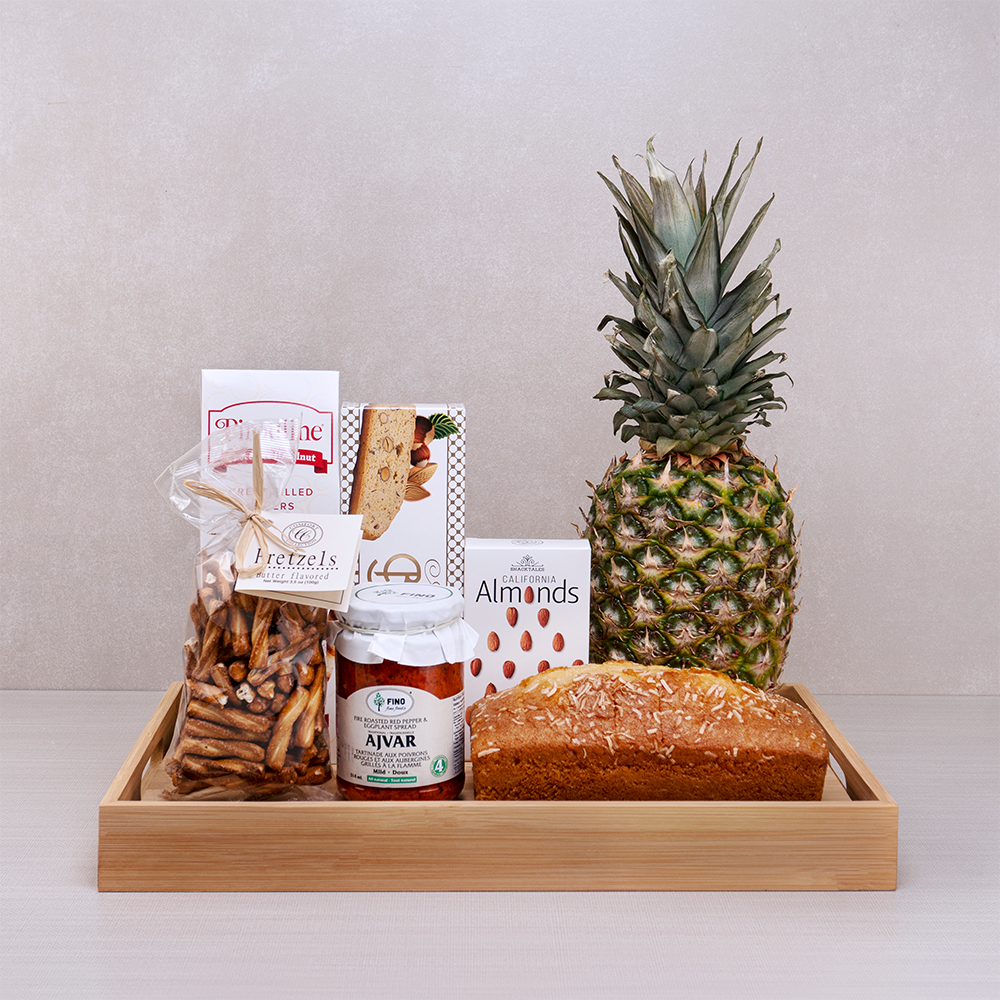 Healing Hugs Sympathy Gift Basket with coconut pound cake, a whole pineapple, ajvar, almonds and pretzels in a bamboo tray