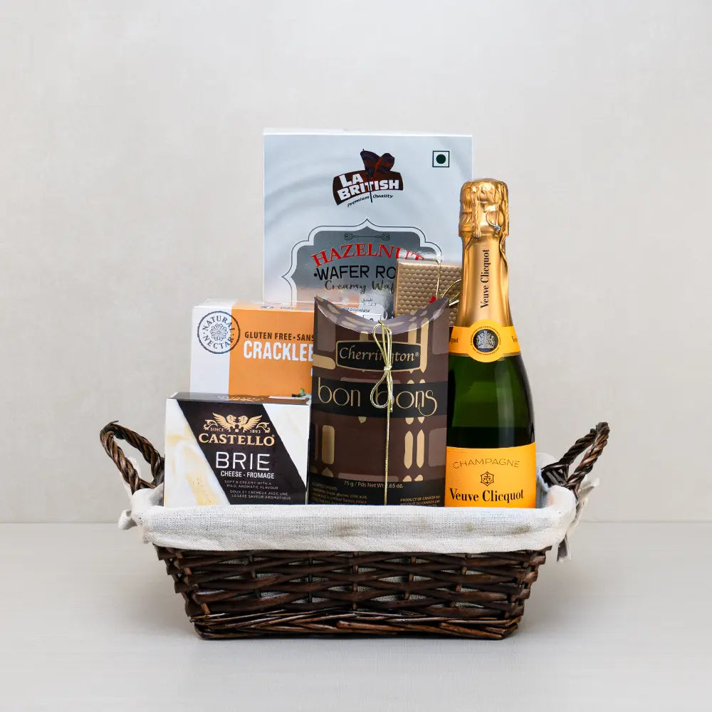 Celebration Champagne Gift Basket with Veuve Clicquot champagne, Castello brie, hazelnut wafer rolls, bonbons and Cracklebred