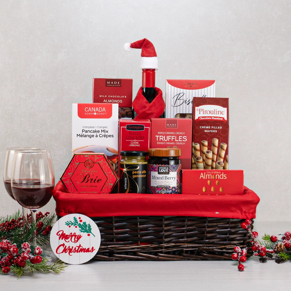 Canadian Christmas Gourmet Basket with wine in a Santa hat, wine glasses, pancake mix and maple truffles in a wicker basket