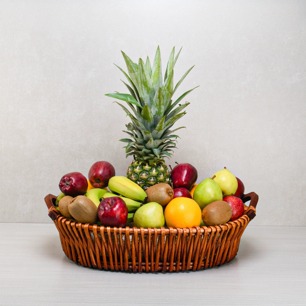 Fresh from the Heart Orchard Basket in woven willow with a pineapple, red apples, bananas, green pears, kiwis and an orange