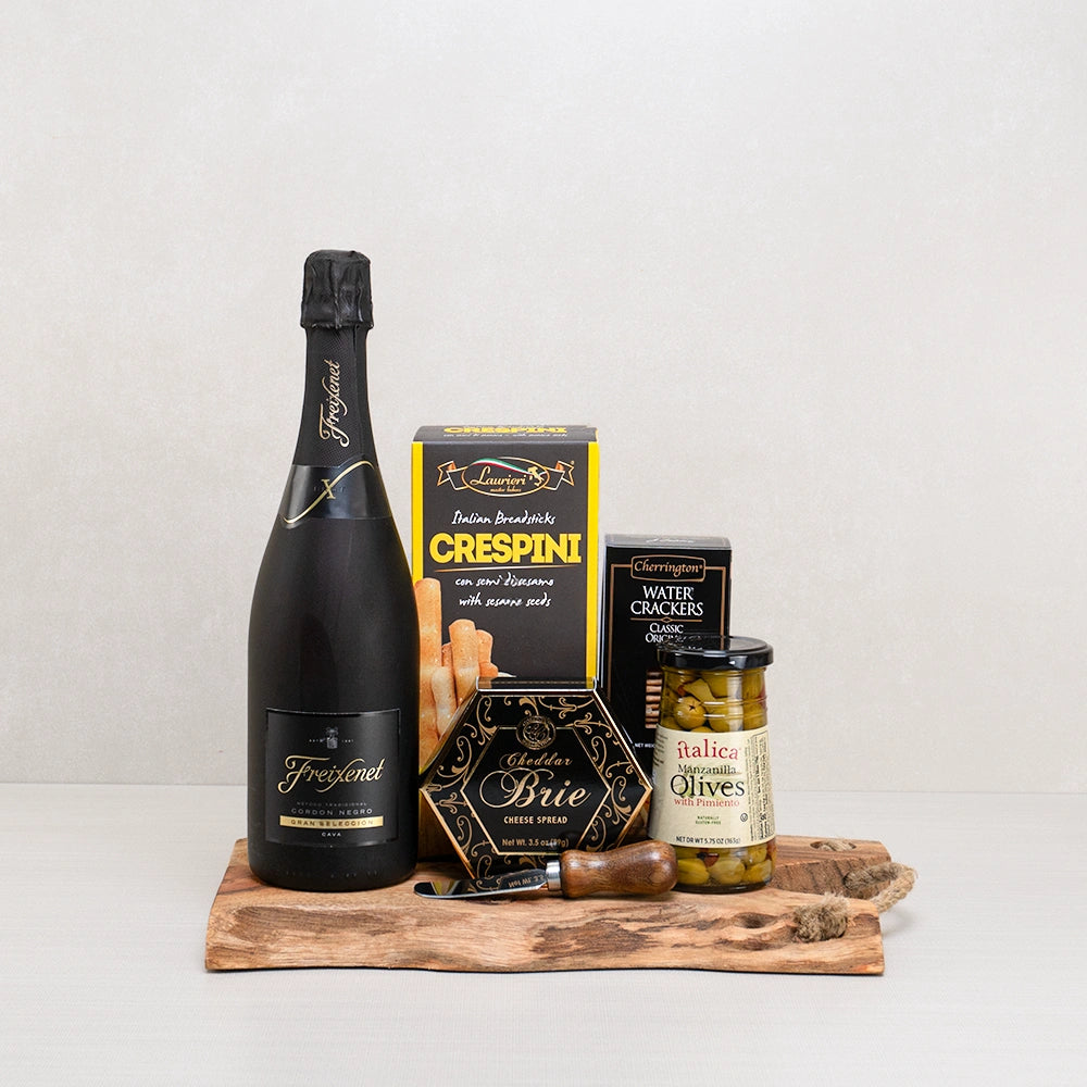 Tasteful Temptations gift set with Freixenet Cordon Negro cava, cheddar brie spread and olives on a live-edge wood board