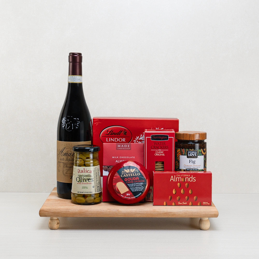 Amanti Red & Cheese Indulgence gift basket with Italian red wine, Castello Gouda, Lindt Lindor and fig preserve on a board