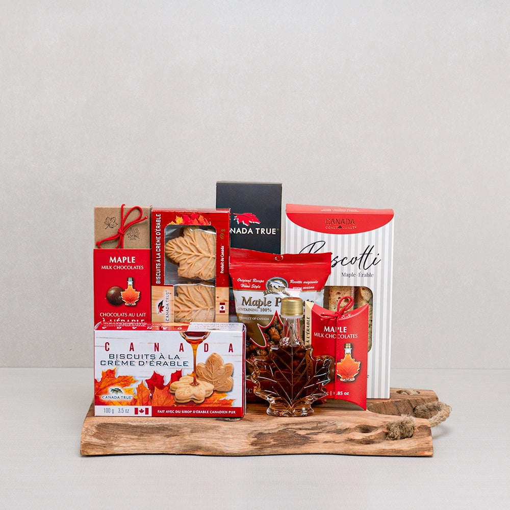 Pure Canadian Maple Delights gift set with maple leaf cookies, maple syrup, maple peanuts and biscotti on a live-edge board