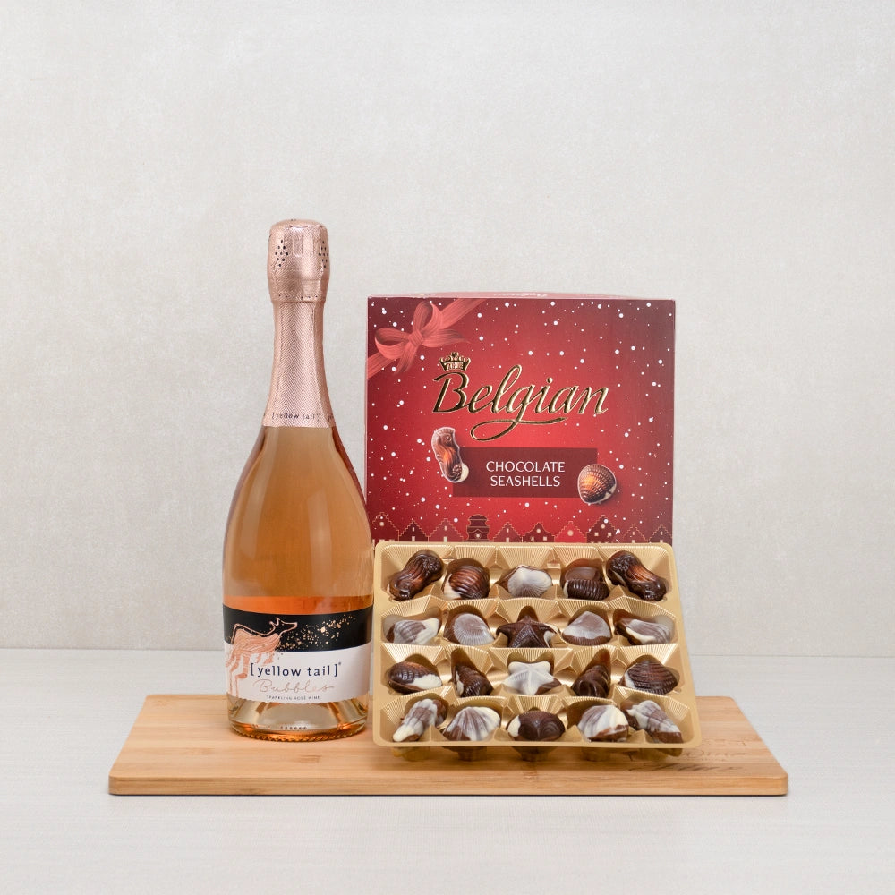 Sparkling Romance Gift Set with Yellow Tail Bubbles rosé and a box of Belgian chocolate seashells on a bamboo board