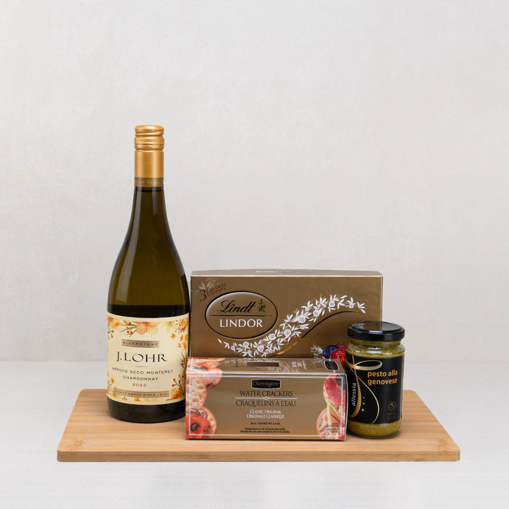Vintage Wine & Classic Gourmet Selection gift set with J. Lohr Chardonnay, Lindt Lindor, crackers and pesto on a bamboo board