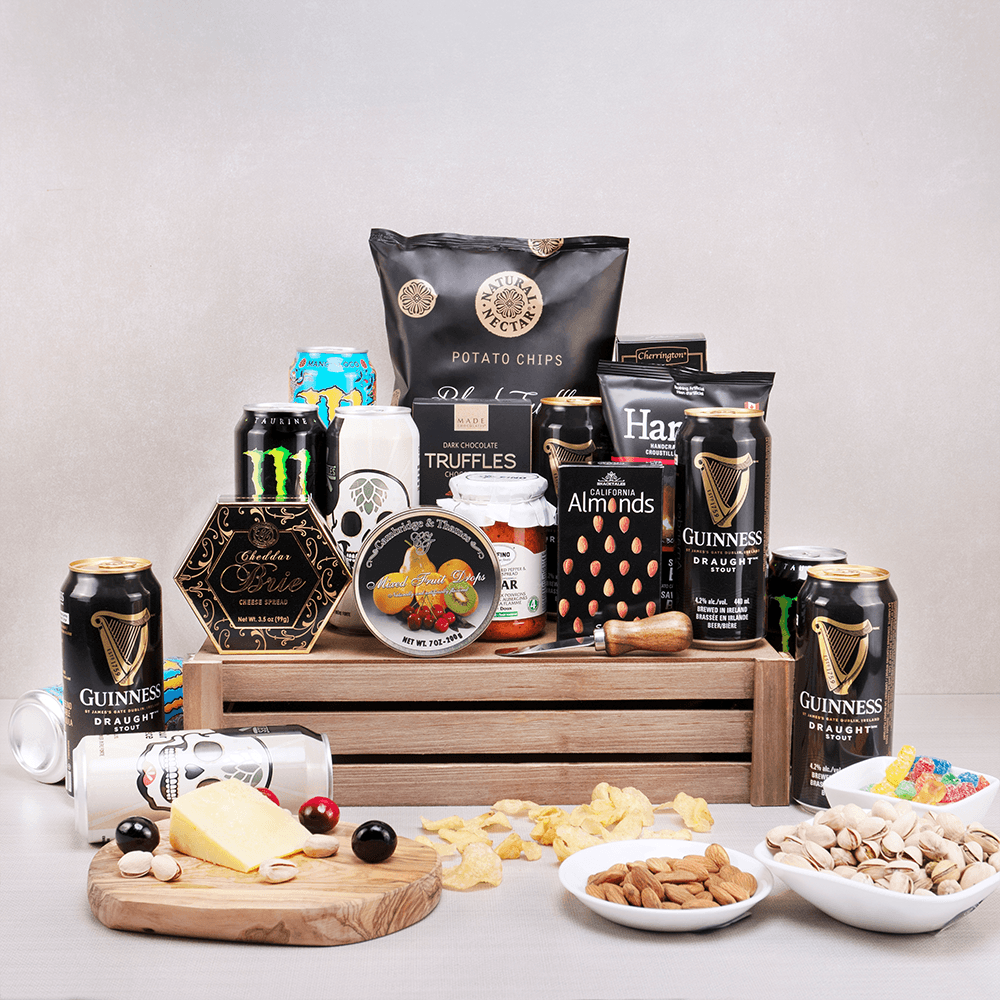 All Night Fright Party Basket with Guinness, Monster Energy, skull-label beers, chips and brie spread on a wooden crate