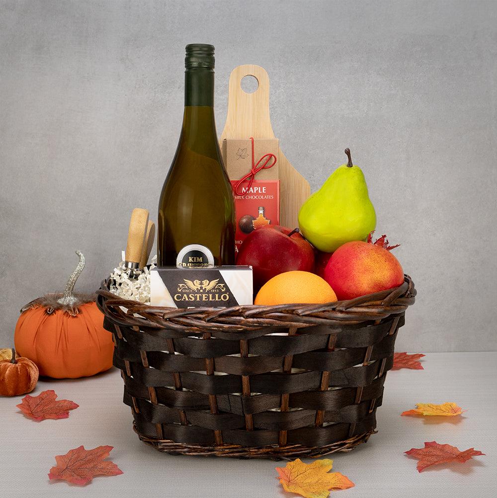 Thanksgiving Day Celebration Basket with white wine, a pear, apples, an orange, Castello brie and cheese knives in wicker