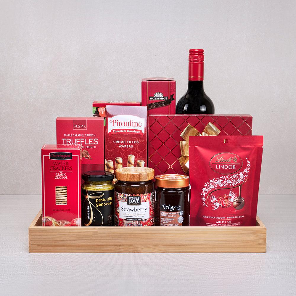 The Christmas Morning Gift Basket with Wine: red wine, Lindt Lindor, Pirouline wafers, pesto and honey on a bamboo tray